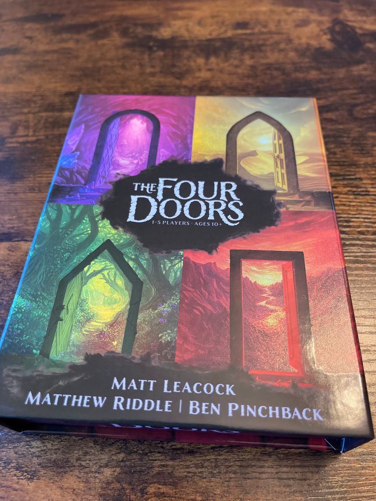 Game box for “The Four Doors”.  Cover art is, unsurprisingly, four doors, one red, one green, one yellow and one purple.