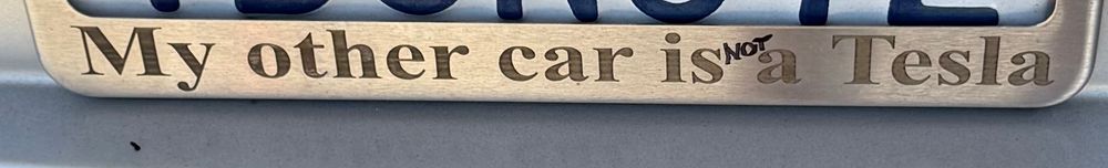 License plate holder saying “My other car is NOT a Tesla”