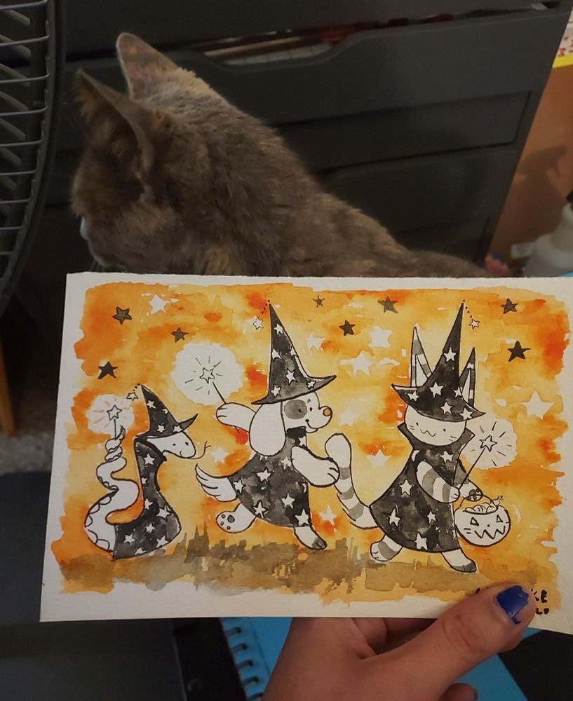 Ink painting of a snake, a dog, and a cat wearing starry robes and pointy hats.

A beautiful cat isn't facing the camera behind the paper.