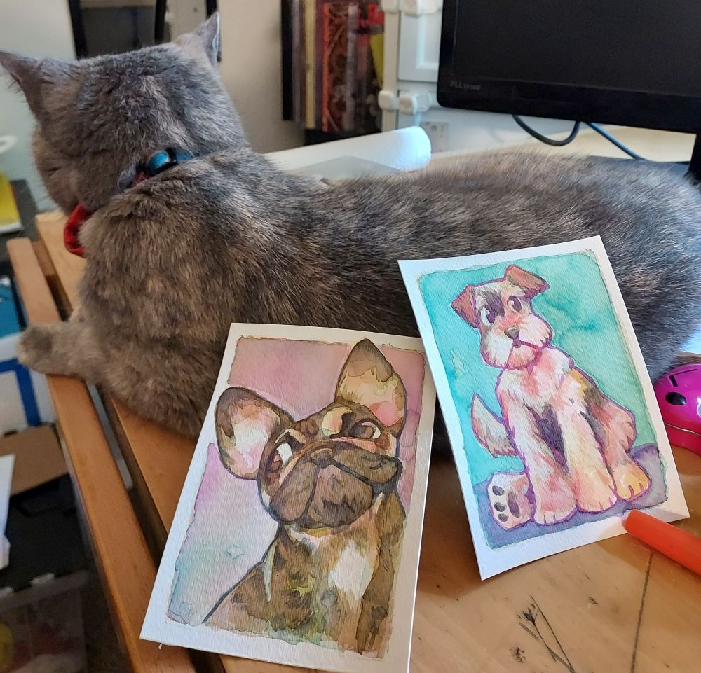 Watercolor paintings of a French bulldog and a schnauzer, being propped up by the most beautiful cat in the world