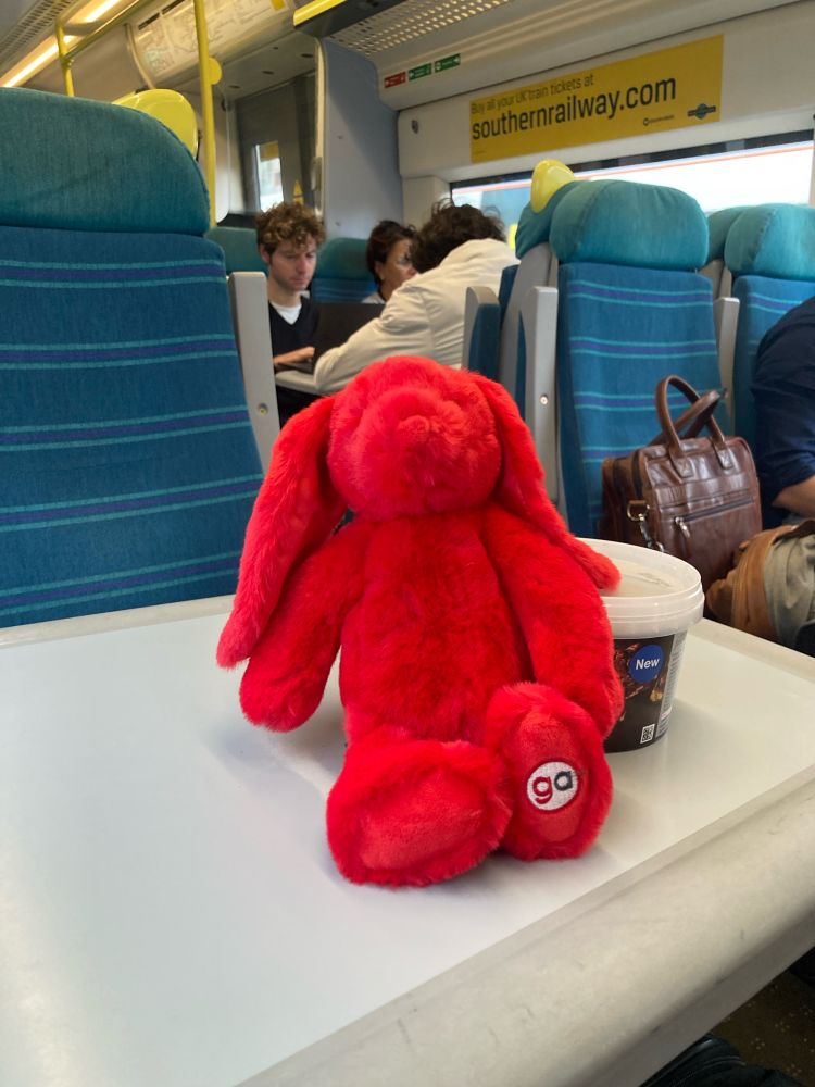 Greater Anglia’s red hare mascot pictured on the table of a Southern Class 377. The hare’s back is resting on a box of rocky road chocolates.