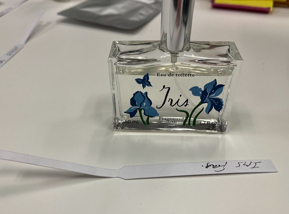 perfume bottle that has a blue Iris flower and the word Iris. 