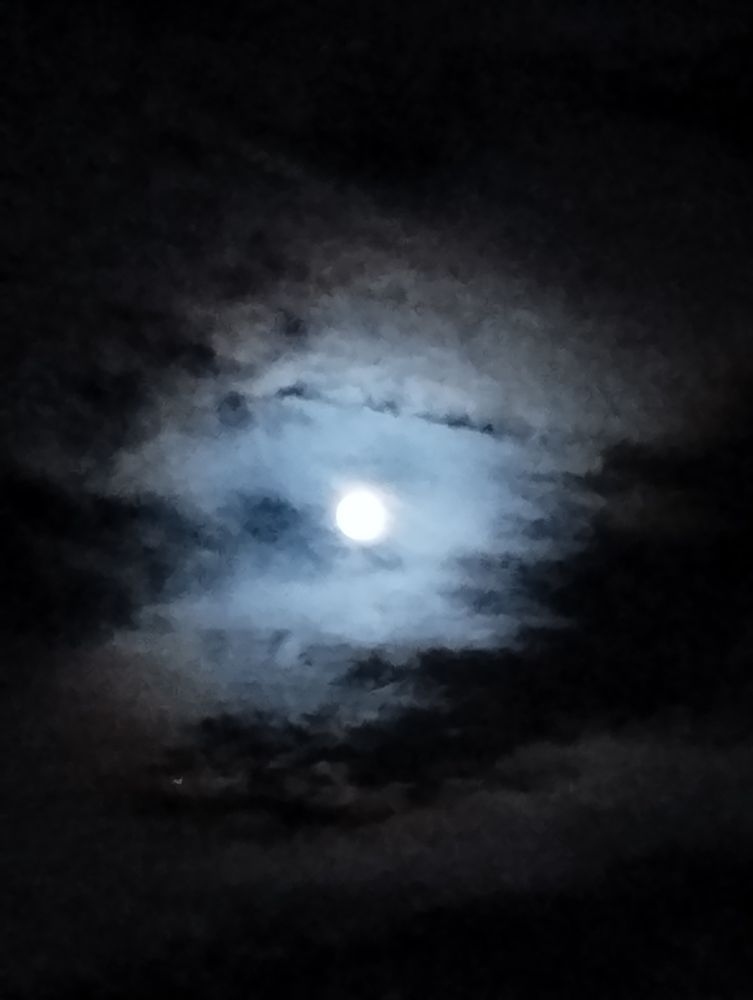 Pleine lune partiellement cachée par les nuages, cela donne une impression de flou
