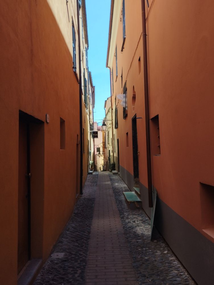 Une rue étroite en Italie. Les murs sont orange. 