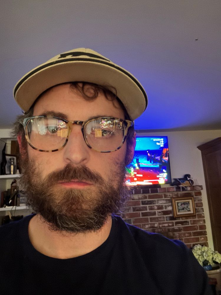 Selfie of me(a white male with a beard) wearing glasses and a hat. 