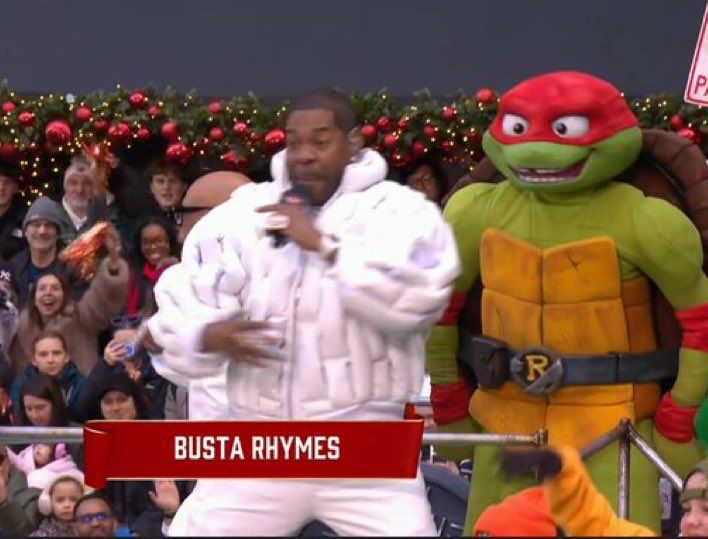 Busta Rhymes rapping in front of maniacal looking ninja turtle 