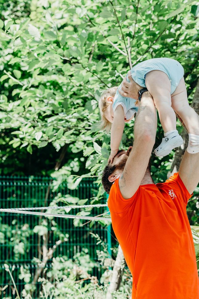 A dad lifting up his young child
