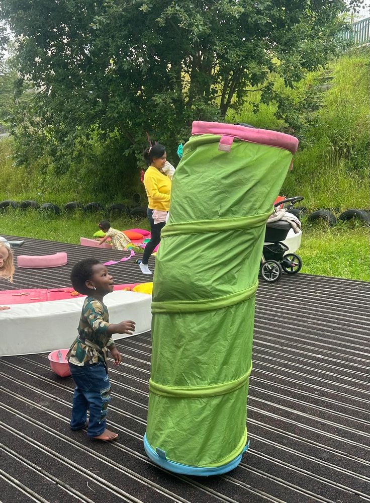 Young child curious about their parent hiding in a tunnel
