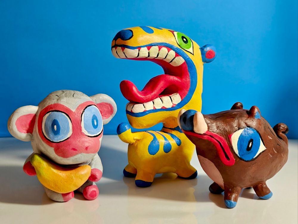 Clay sculptures of a monkey, tiger, and boar.