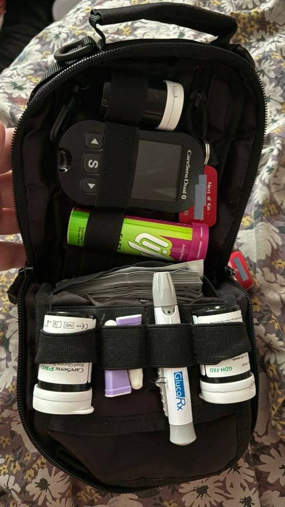 Black pouch bag with blood glucose meter and other accoutrements. 