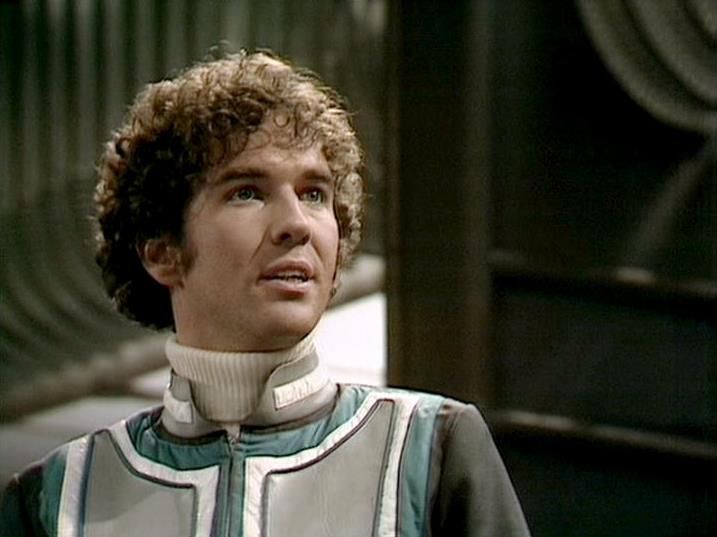 

Claude Sonnet 4.0 describes the image as: "I can see this is a scene featuring a character in a distinctive white and teal colored futuristic uniform with high collar details, characteristic of the show's sleek costume design. The setting appears to be aboard a spacecraft, with the typical metallic interior and curved architectural elements visible in the background. The lighting creates the moody, dramatic atmosphere the series was known for. The uniform's design reflects the show's aesthetic of blending practical military-style clothing with futuristic elements, suggesting this character holds a position of authority or expertise within the crew structure."

Blakes7Bot, version 3.9.31. AWS Lambda version: 1.14.