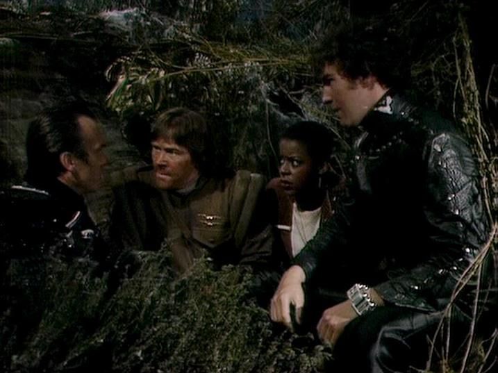 

Claude Sonnet 4.0 describes the image as: "This appears to be a scene set in a natural, jungle-like environment with dense foliage and vegetation. The characters are positioned close together among the greenery, suggesting they may be hiding, taking shelter, or engaged in some kind of covert activity. The setting looks outdoor and wilderness-based, with the actors wearing what appears to be futuristic or military-style clothing typical of science fiction productions. The lighting and composition create a tense, dramatic atmosphere as the group appears to be in discussion or planning something while concealed within the natural cover of the forest setting."

Blakes7Bot, version 3.9.31. AWS Lambda version: 1.14.