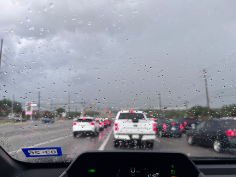 מכוניות ברמזור אדום וברקע גשם שוטף בסופה של אתמול אחר הצהרים 