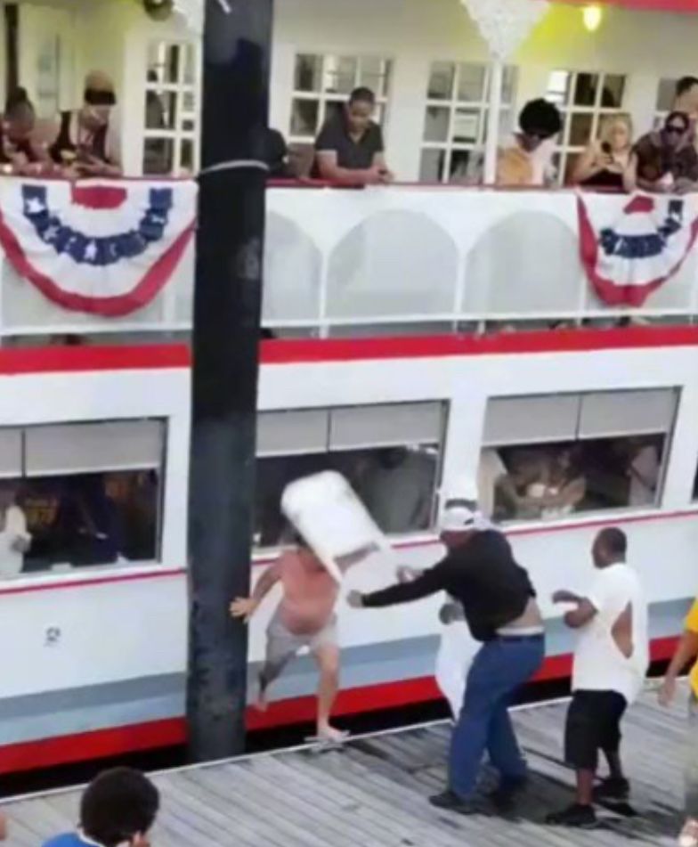 A man being hit in the head with a folding chair during a fight on the Montgomery, Alabama waterfront. 