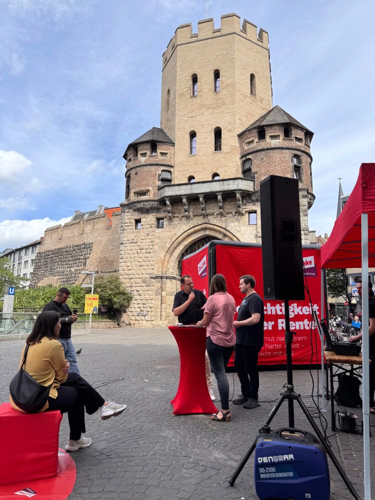 Sören Pellmann und Lea Reisner, in einem Gespräch vor einem Stadttor in Köln