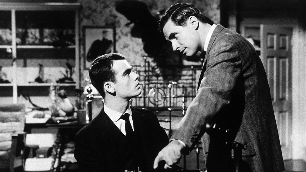 Bradford Dillman leaning over Dean Stockwell and pointing to the foreground