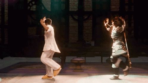 a man and a woman are dancing on a stage in a dark room