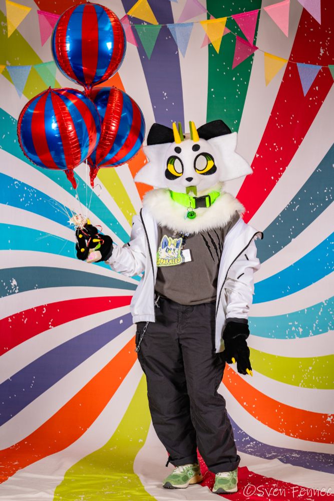 a photo taken of me in partial fursuit at furcationland 2025. i'm holding balloons and facing the viewer. 

tags: #fursuit #furry