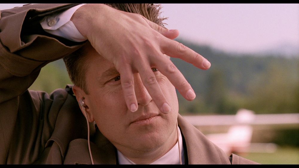 Gordon Cole placing his upside down hand over his face, fingers spread