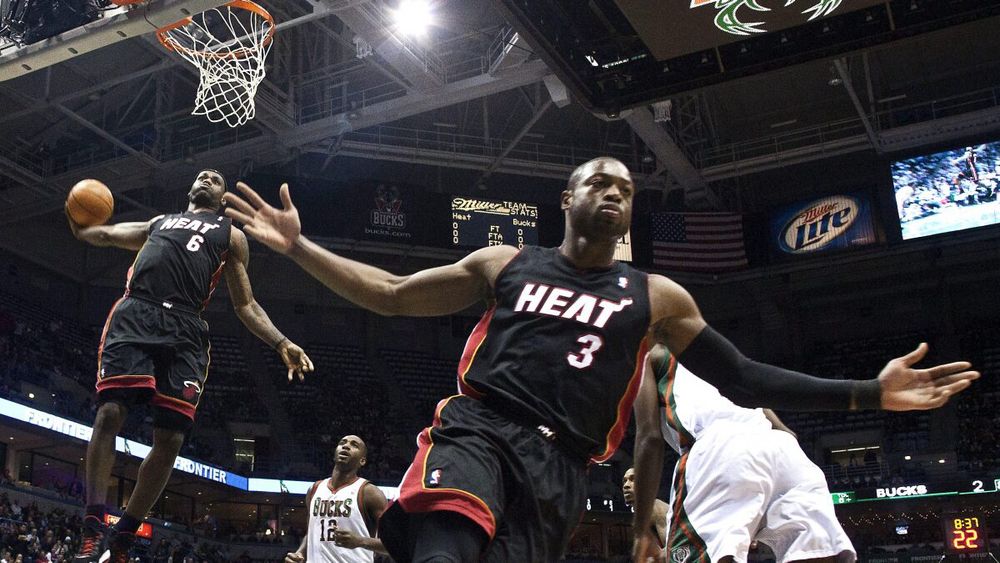 LeBron to DWade dunk connection image. #3 on the Heat (Wade) in the foreground with arms outstretched, #6 (LeBron) in the middle of a tomahawk dunk behind him