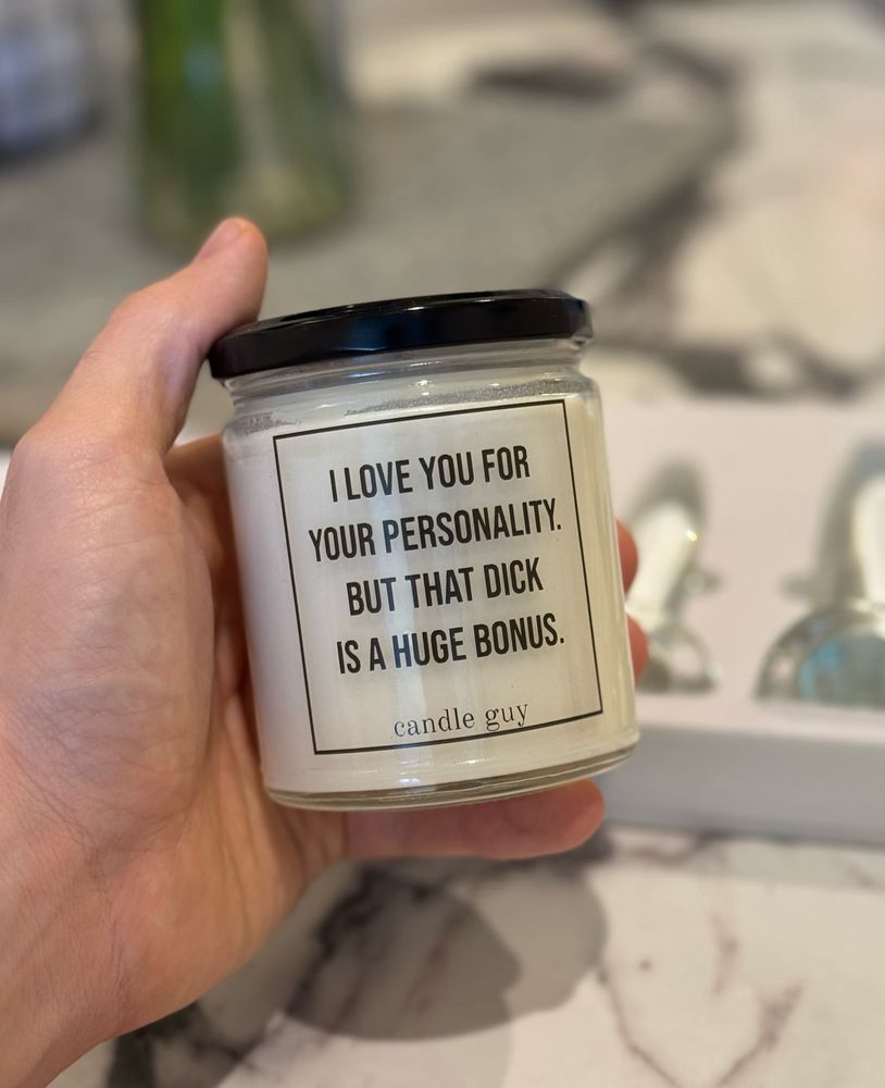 User is holding a white candle with the inscription “I love you for your personality, but that dick is a huge bonus”