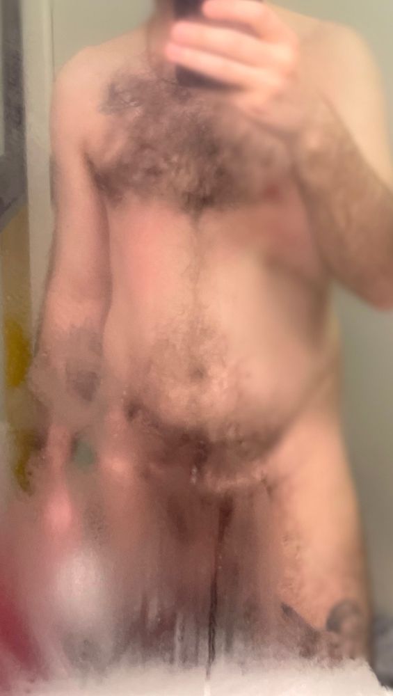 Man reflected in a steamy mirror, naked. 