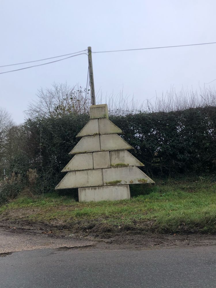 A Christmas tree made out of concrete blocks by the side of the road.