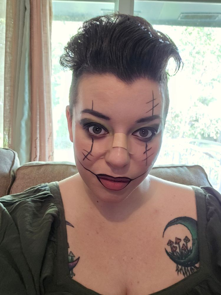 Selfie with low key clown makeup (black liner down the eyes and across the lips extending into a grin)