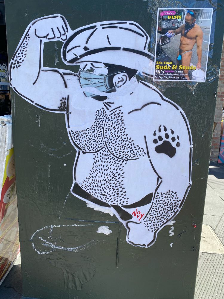Wheat paste art of a bear in a cowboy hat flexing his arm; he is hairy chested and is wearing a mask. He has a bear paw tattoo. The art is by Jeremy Novy; the artist signature NOVY is in red next to the strap of the underwear 