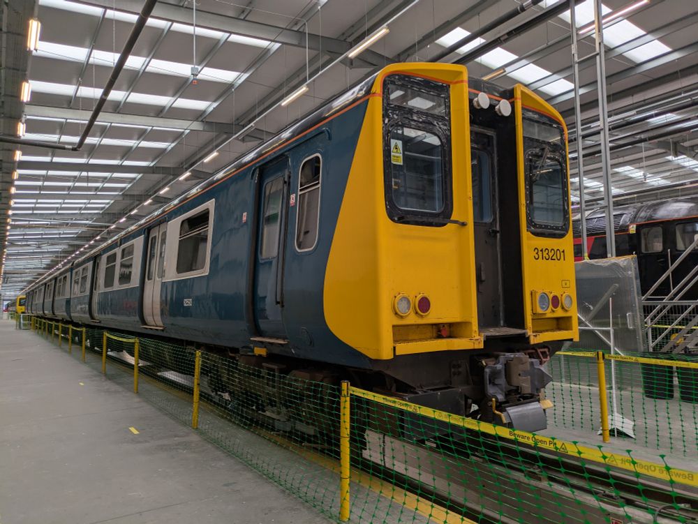 A Class 313 train inside a modern, bright train shed