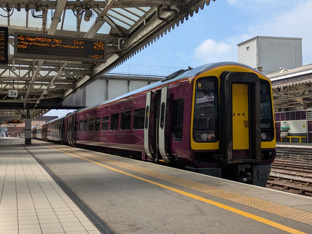 A Class 158 train in East Midlands Railway all over purple livery at Sheffield train station 