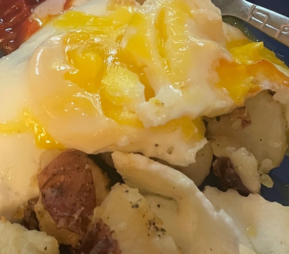 Bright yellow and white eggs on top of potato chunks.