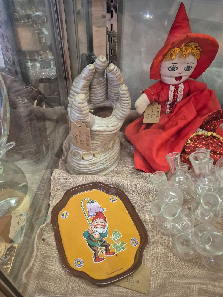 A hand from the wrist up made of clay, built up from a coil in a spiral pattern.  The fingers and palm terminate in holes.