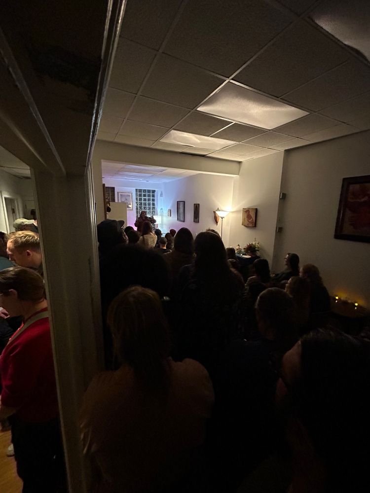 That same packed room from the previous photo but from all the way in the back, where you can see the overflow into the hall