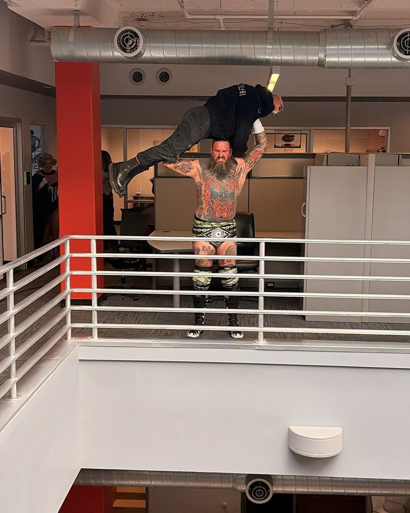 Brody King hefting Darby over his head 