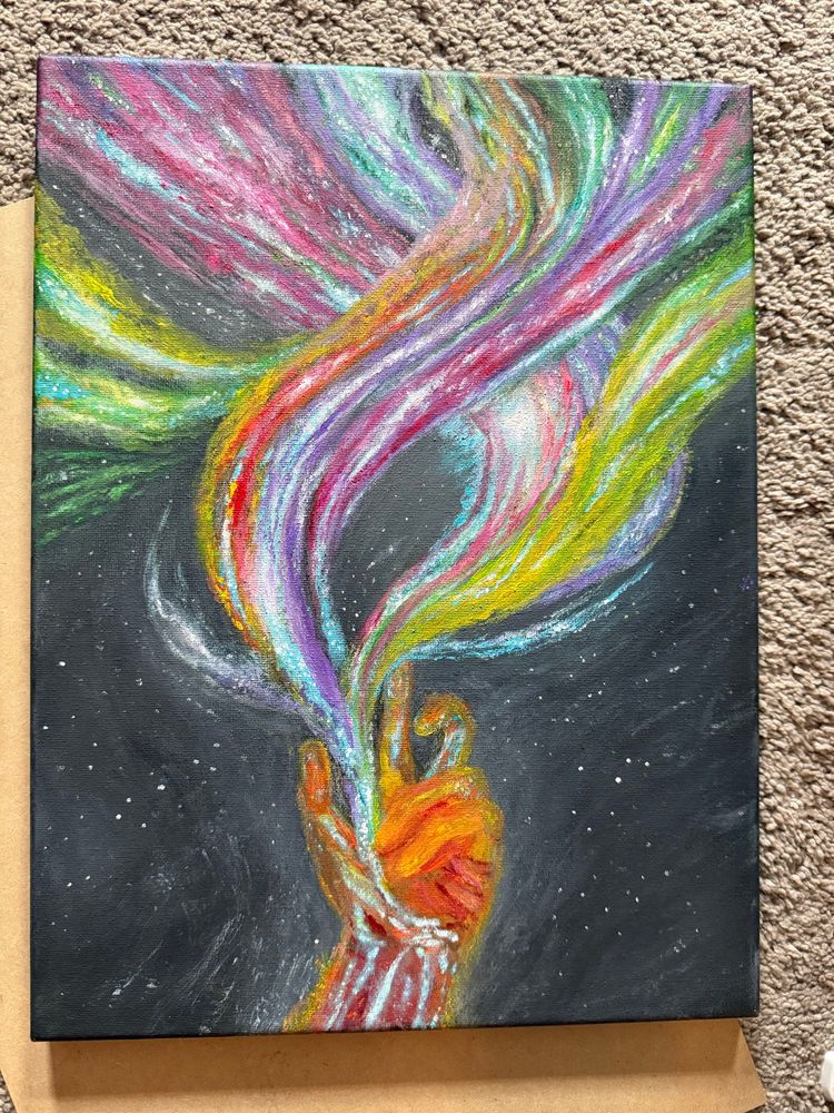 The latest update of my hand painting which I’ve been working on for a year now on and off. It is of a hand made of space dust and stars with colors and light bursting out of it in many directions like tentacles. The hand is primarily shades of orange with pale blue and white light where the veins would be. A glow emanates from the hand. Along the lifeline of the palm the light bursts out of the hand into multiple streams, shooting off upwards and spreading out. They are many colored-some green, yellow, orange, shades of pink, blue, teal and lavender and full of stars. In the background is black outer space with white stars.