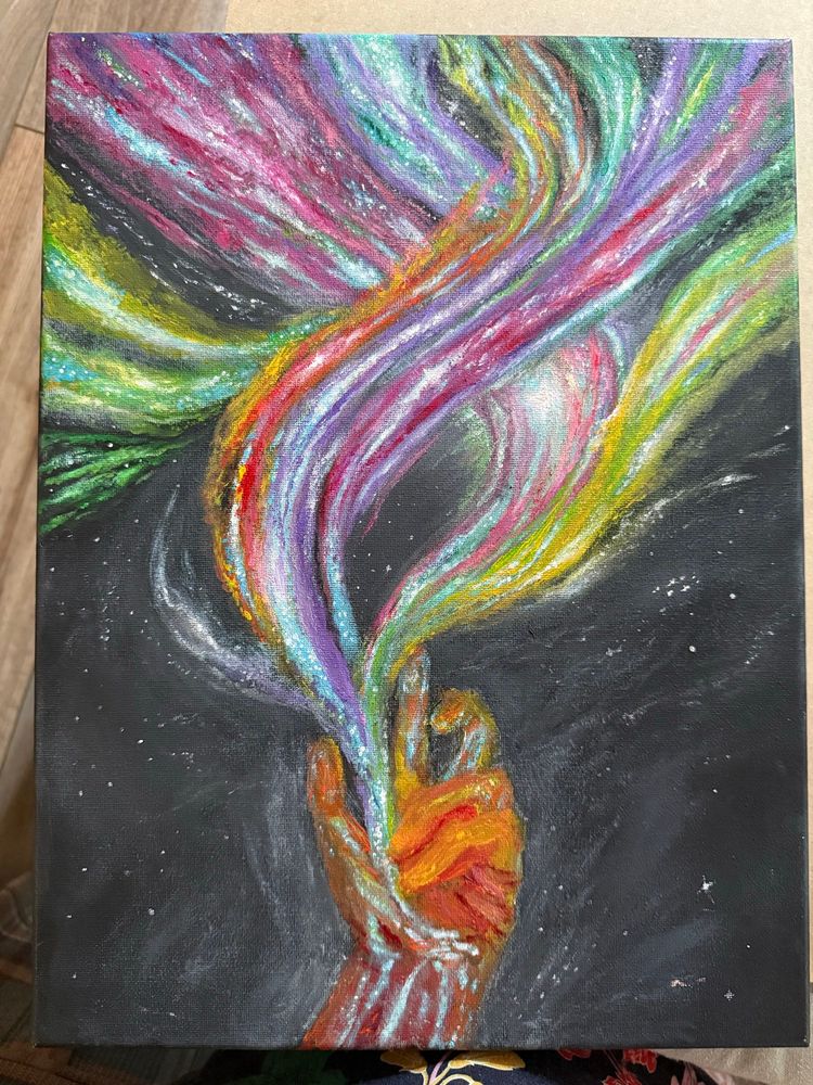 My painting in progress. It consists of a hand made of stars and a predominantly orange nebula shooting out strands of colors and stars upwards in many directions like tentacles against a black background with white stars. From left to right the nebula is primarily yellow and green, followed by pink, then teal and purple, orange and pink, and more green and yellow. Toward the center of the colors shooting outward is a very large star with an arc of light around it.