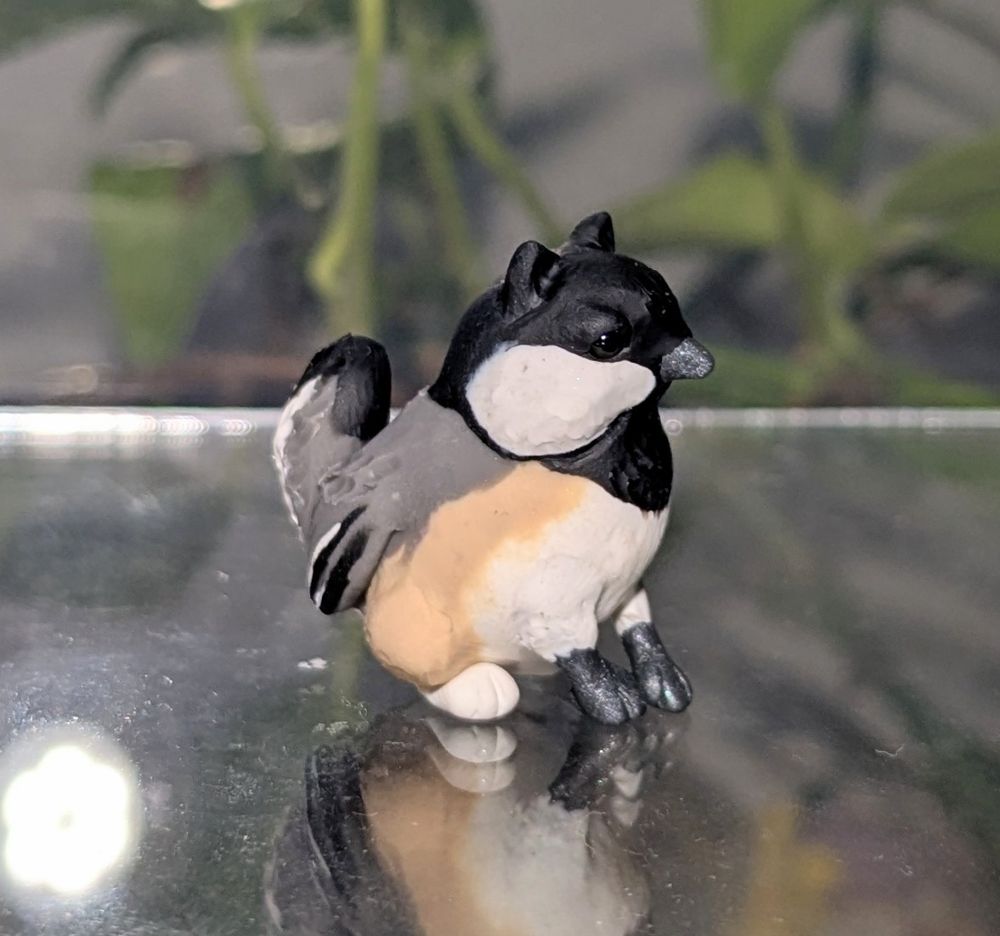 A figurine of a very round gryphon with Chickadee features. He is alert!