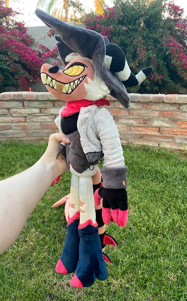 Striker plush being held up from the side