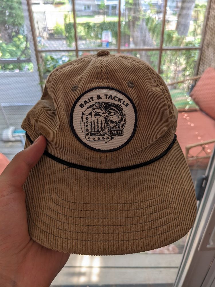 A corduroy hat with a fishing illustration and the words "Bait & Tackle" 