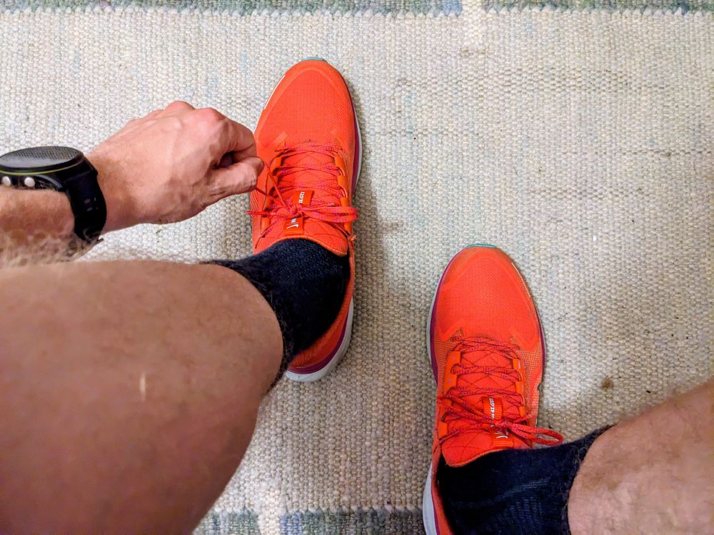 Orange running shoes being tied before a run