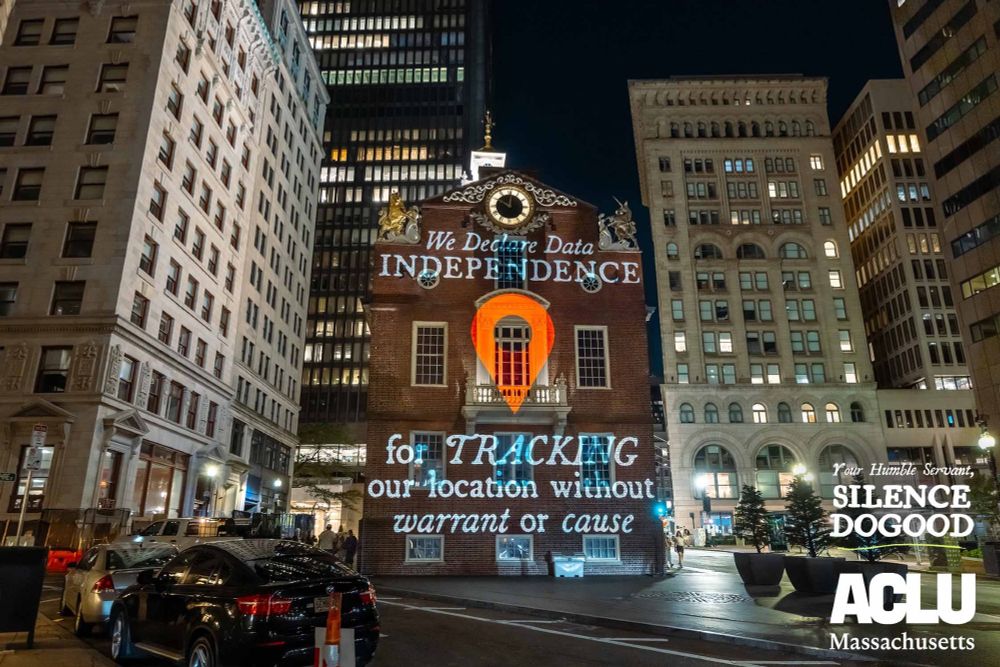 Silence DoGood projection on the Old State House reading "WE declare data independence for TRACKING our location with our warrant or cause."