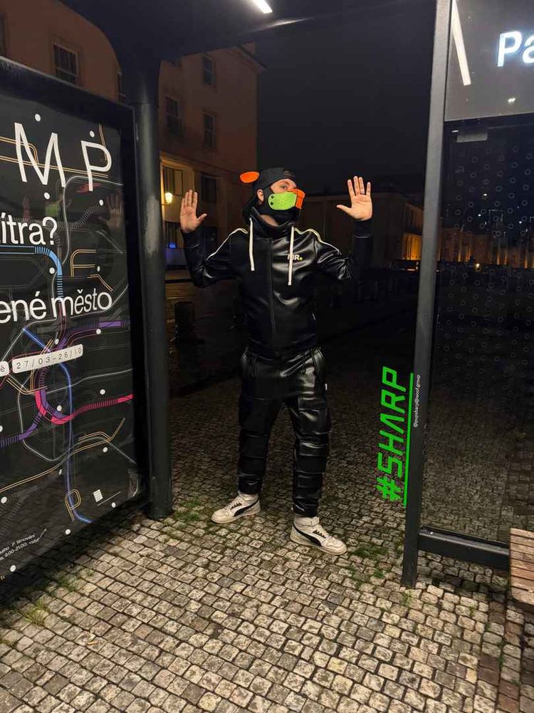 The petplayer sharp is miming a mime at a bus station at night