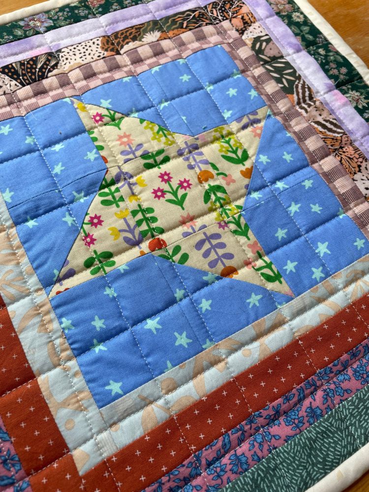 A closeup of the quilt so you can see the grid quilting and fabric patterns.