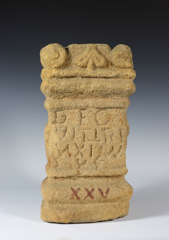 Front face of a sandstone altar. There is an inscription in latin