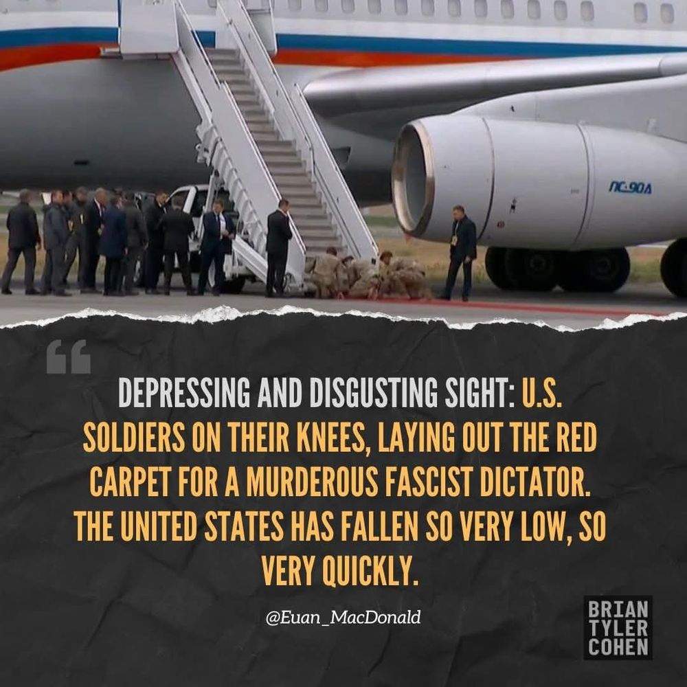 Image shows a red carpet being laid outside of Russia's plane by u.s. soldiers on their hands and knees in Alaska 2025. DEPRESSING AND DISGUSTING SIGHT: U.S. SOLDIERS ON THEIR KNEES, LAYING OUT THE RED CARPET FOR A MURDEROUS FASCIST DICTATOR. THE UNITED STATES HAS FALLEN SO VERY LOW, SO VERY QUICKLY. @Evan_MacDonald 
