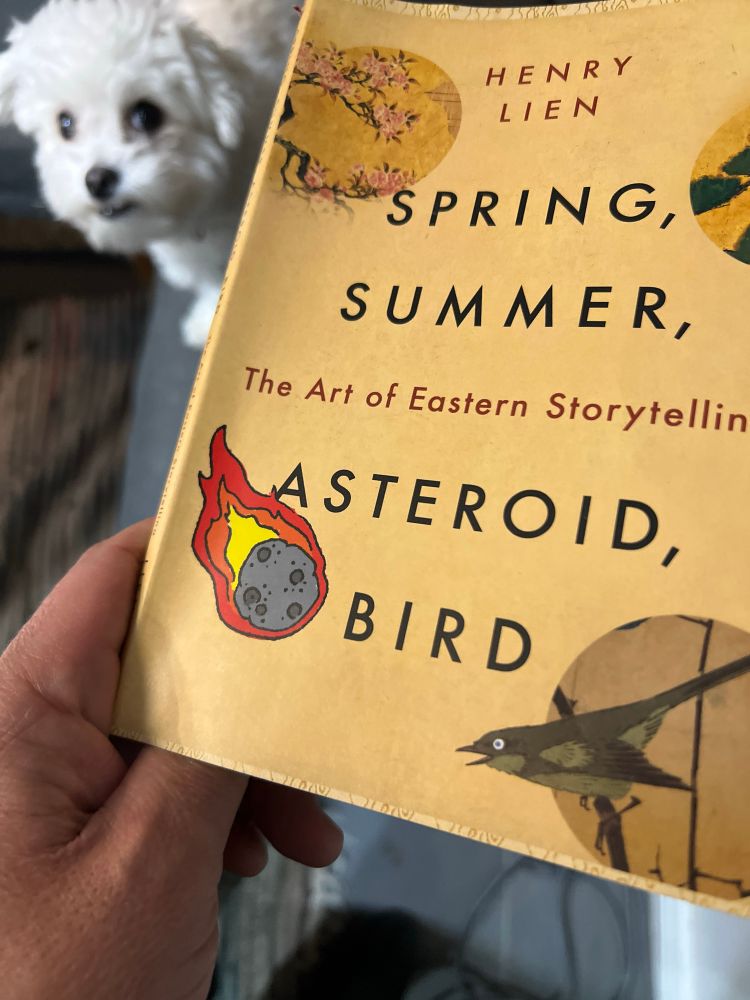 A picture of a book with a small dog in the background