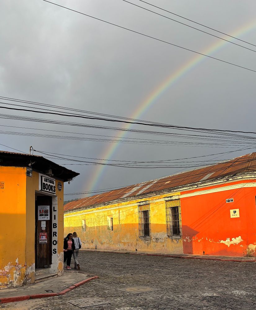 Photo of the bookshop with a beautiful rainbow that appears to end at the store.