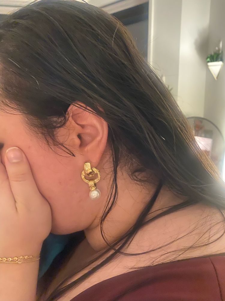 earring with 3 chunky gold interlocking rings with a pearl at the bottom of the last one