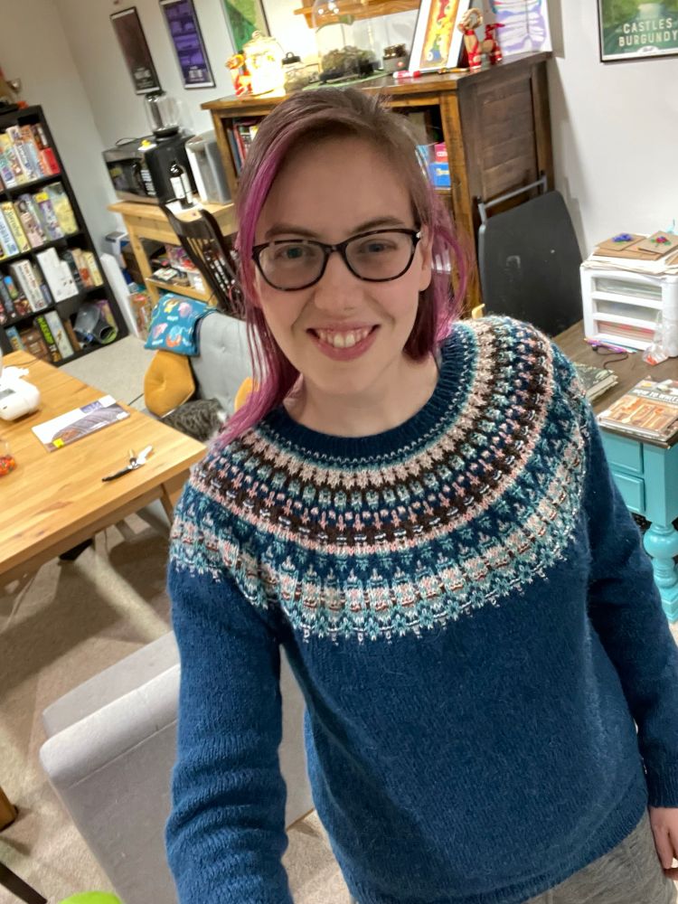 Finished lunenburg pullover, a colorwork yoke sweater by Amy Christoffers. Knit in Rauma Finull and Rauma Tumi yarn. Shown on a person trying their best to use a selfie stick.